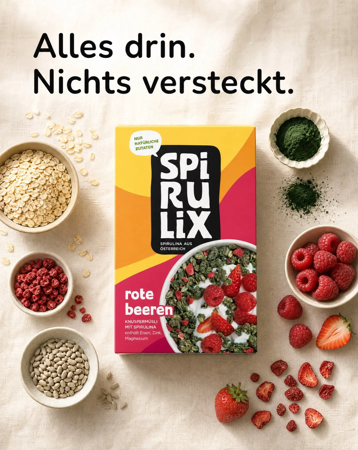 Overhead SPIRULIX Rote Beeren carton on linen surrounded by oats, berries, seeds and spirulina powder