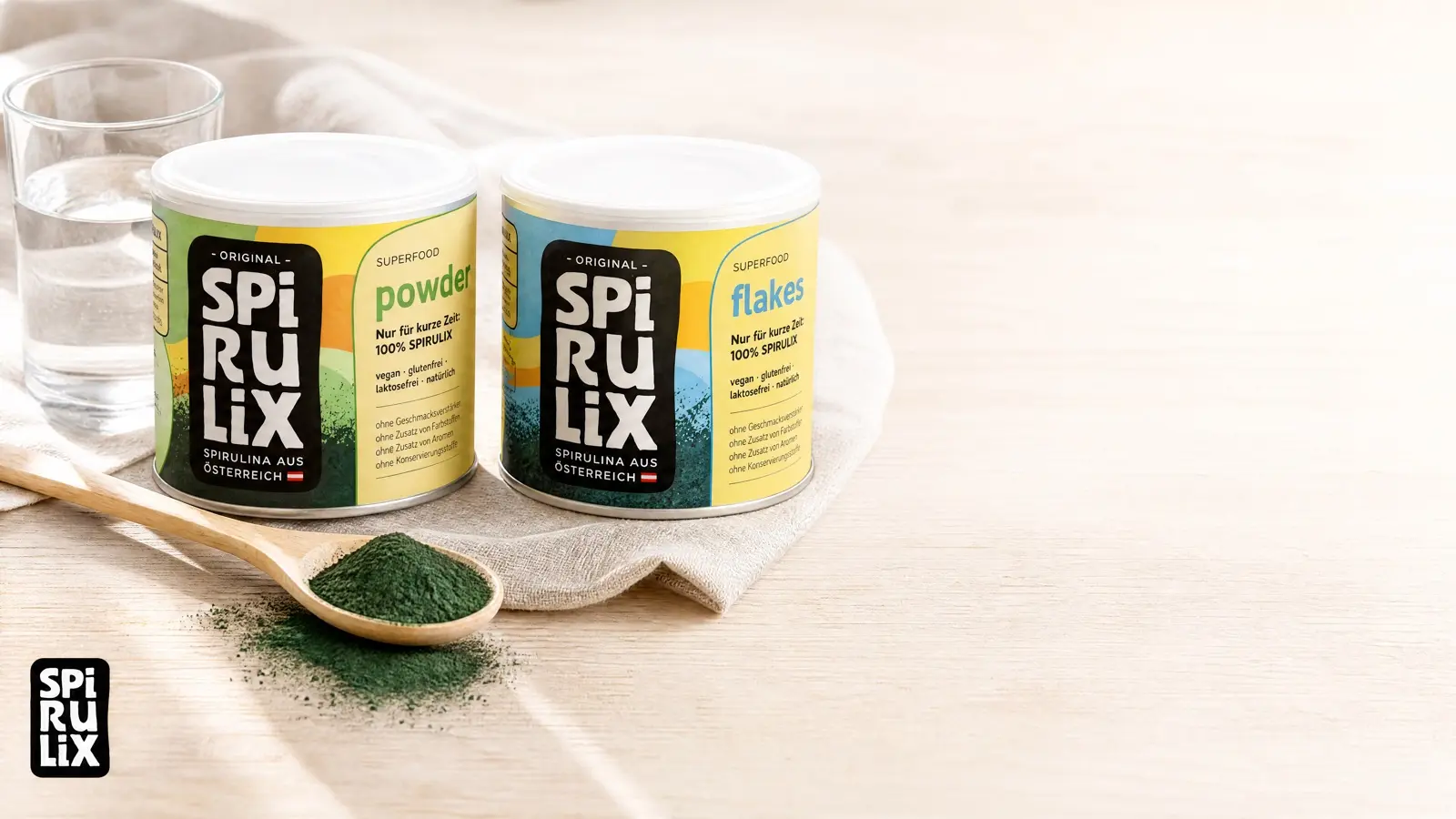 SPIRULIX Powder and Flakes tins on linen with a spoon of green powder